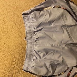 Grey nike shorts with flowers on bottom edges .